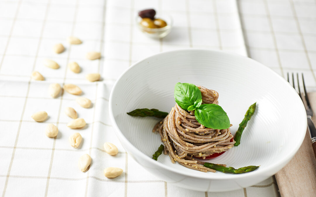 spaghetti di grano saraceno con pesto di mandorle e olive, asparagi e basilico