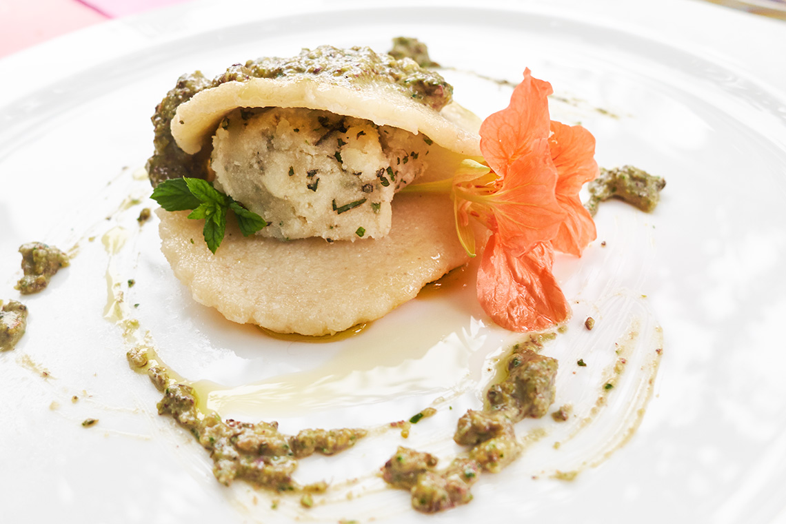raviolo aperto alle erbe su pesto di menta e pistacchi