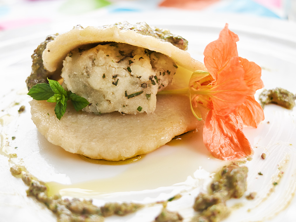 raviolo aperto alle erbe su pesto di menta e pistacchi