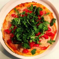 Pizza in pasta di ceci con rucola e pomodorini