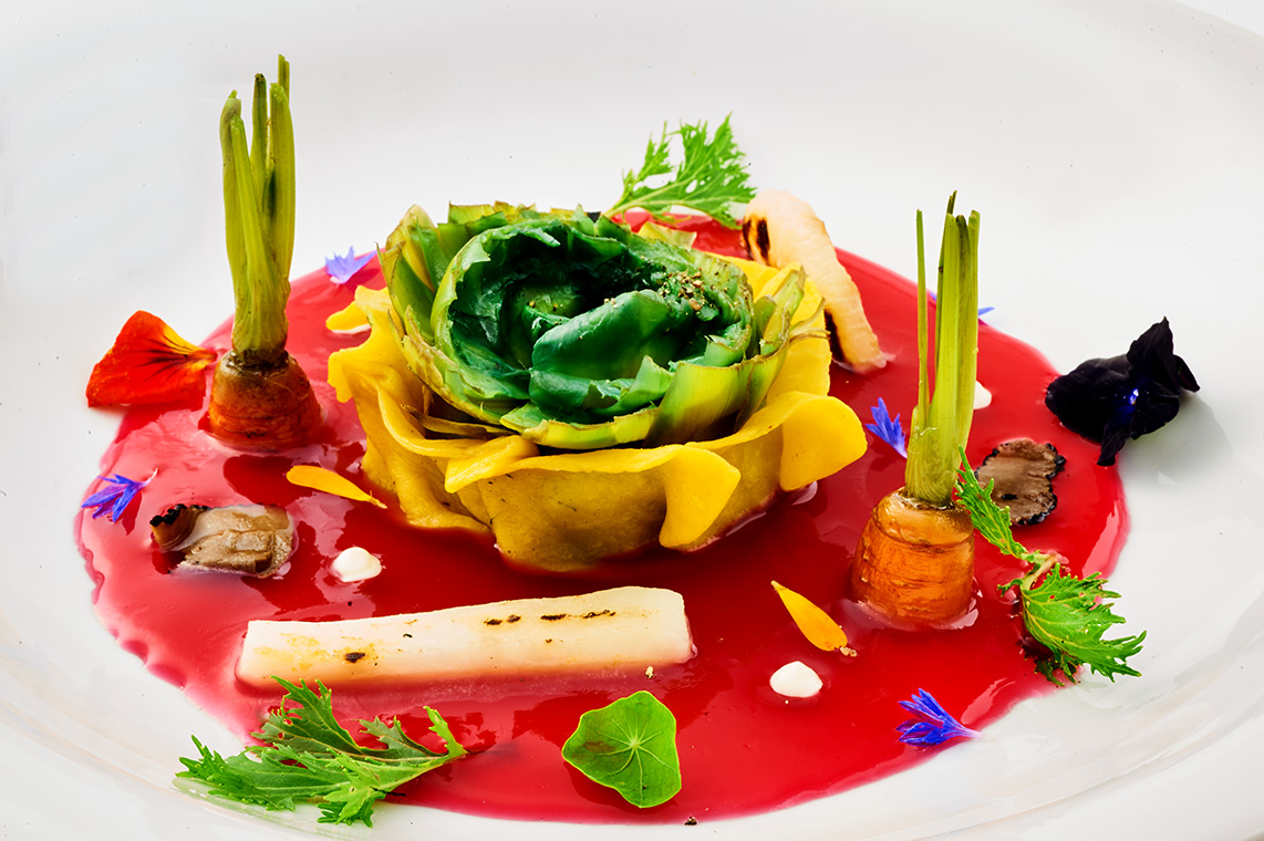 Raviolo aperto al carciofo con brodo leggero di ibiscus piccante, verdure croccanti e tartufo Raviolo aperto al carciofo con brodo leggero di ibiscus piccante, verdure croccanti e tartufo